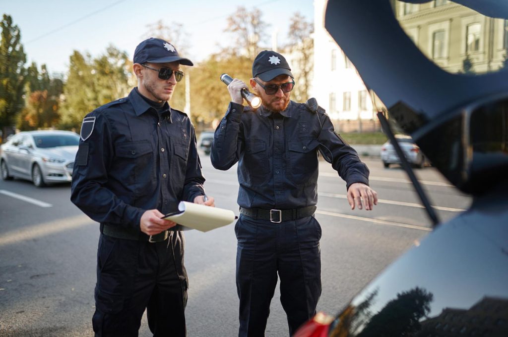 Dva policajca pregledaju obaveznu opremu u automobilu.