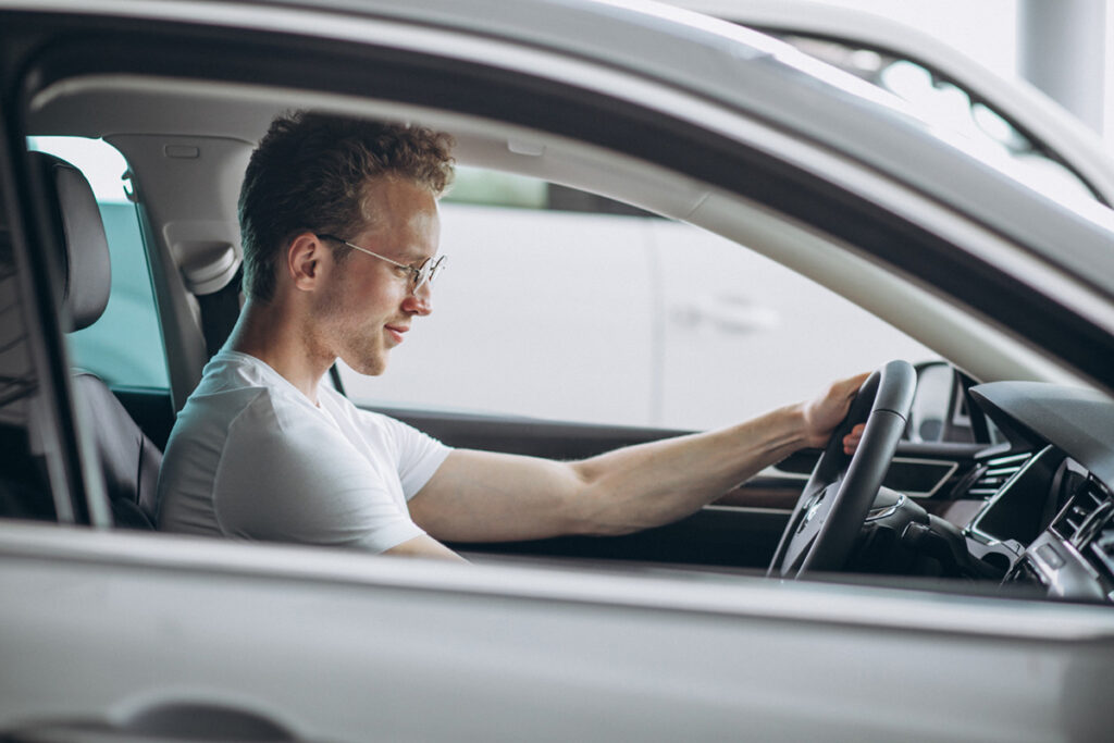 Momak obavlja probnu (test) vožnju pre kupovine polovnog automobila