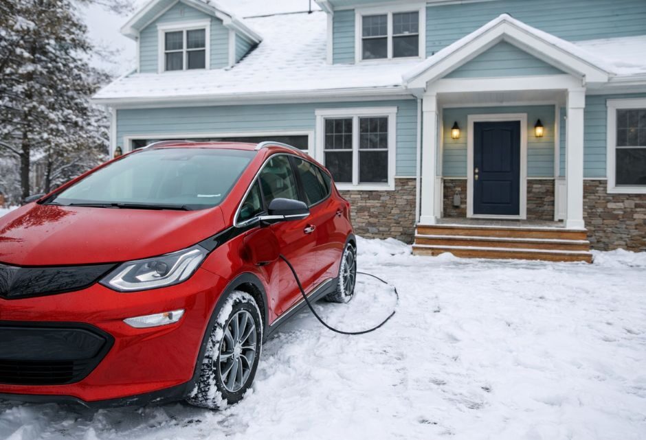 Punjenje električnog automobila na kućnom punjaču tokom snežnog zimskog dana